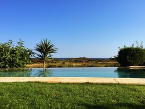 Una piscina con vistas al mar y colinas.