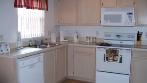 A compact kitchen with a microwave, stove, and sink. - Luxury Villa with Private Pool 8 miles from Disney & near golf (CLERMONT)