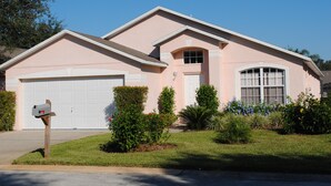 A single-story house with a garage, a mailbox, and a well-maintained lawn. - Luxury Villa with Private Pool 8 miles from Disney & near golf (CLERMONT)