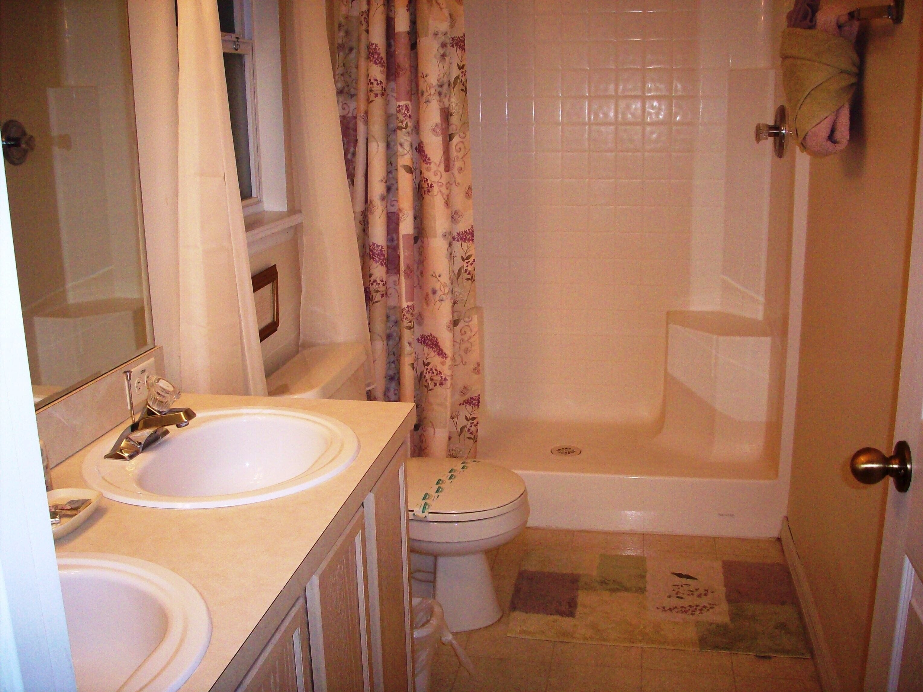 A bathroom with a bathtub, toilet, and two sinks.