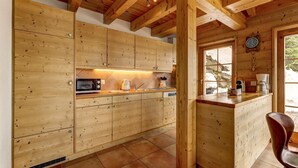Una cocina de madera con armarios, un microondas y un lavabo.