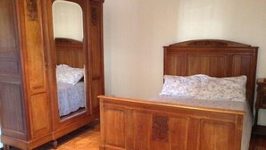 A wooden bed with a headboard and a matching wardrobe with a mirror. - Beautiful, luxurious farmhouse In Champagne. Only 1 Hr From Paris, Near Epernay. (Baslieux-Sous-Châtillon)