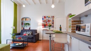 A compact living space with a sofa, coffee table, and a kitchenette area. - Grotta Pinta 7 | Cozy and romantic (Roma)