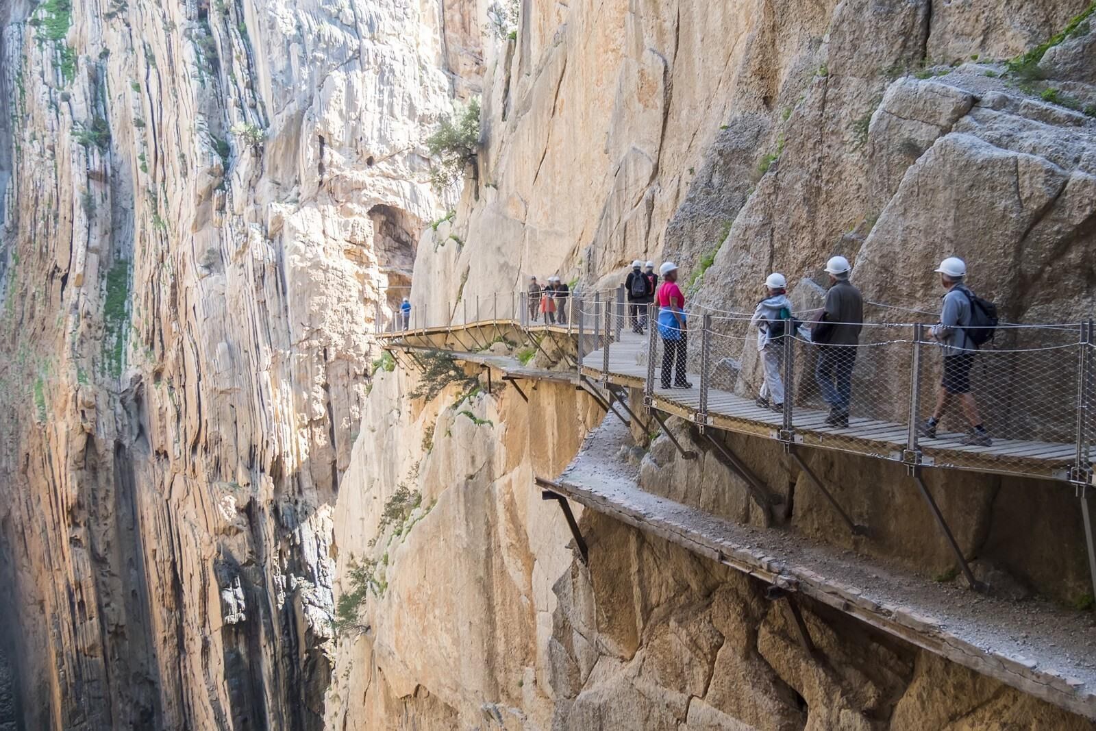 Ein Metallweg mit Geländern, der zu einer Klippe führt.