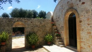 Un bâtiment en pierre, doté d’arcades et agrémenté de plantes en pot.