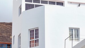 A modern building with large windows and a flat roof. - Apartment next to the beach with free Wifi, SAT TV, sea views (Gran Tarajal - Fuerteventura)