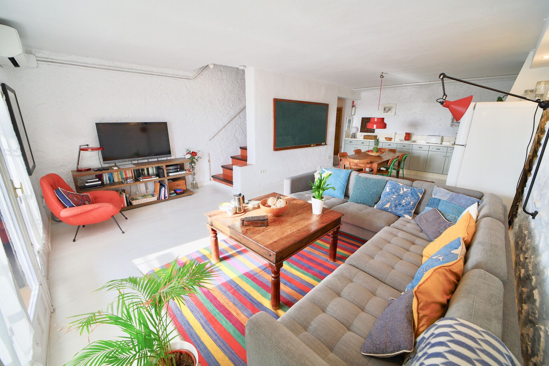Een moderne woonkamer met een bank, een salontafel, een televisie en een boekenkast.