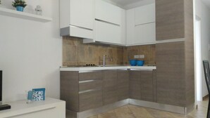 A modern kitchen with a built-in stove, a sink, and a countertop. - VILLA WITH PRIVATE GARDEN NEAR THE SEA (Porto Pino)