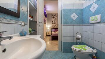Baño con lavabo, inodoro y zona de ducha.