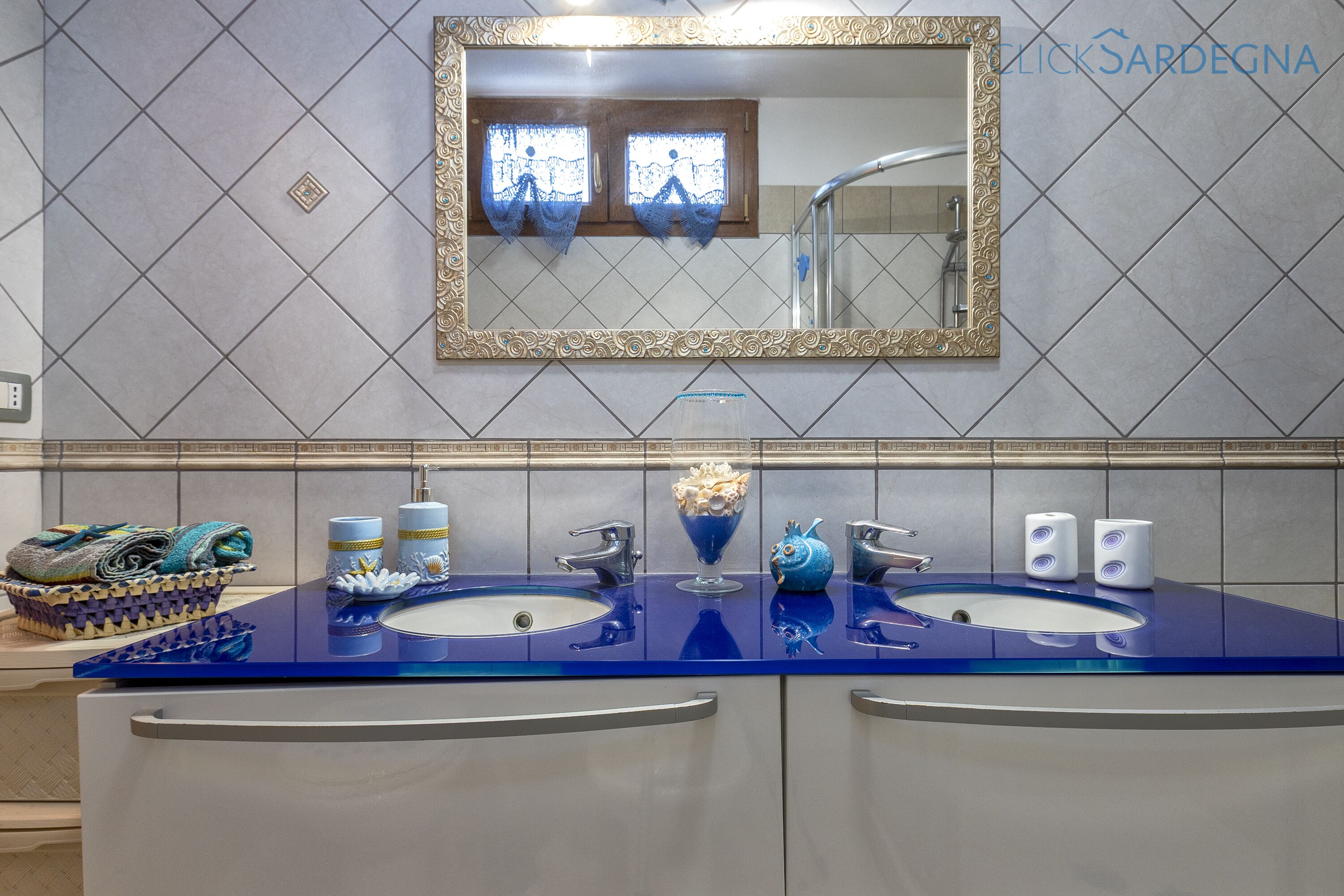 Un baño con dos lavamanos, un espejo y una ducha.