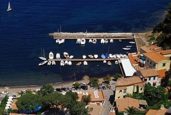 A coastal marina with boats docked, a pier, and surrounding buildings. - Enchanting sea view apartment with large terrace (Portoferraio)