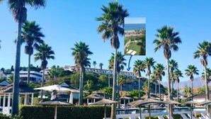 A resort with palm trees, a pool, and beach umbrellas. - Bahia del Mar  with dream views ,climatisation and wi-fi (Casares)