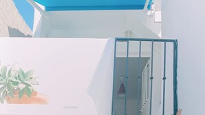 A white staircase with a blue railing leading to a door.