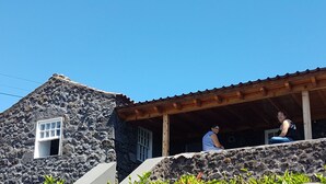 Un edificio in pietra con un portico in legno e una finestra.