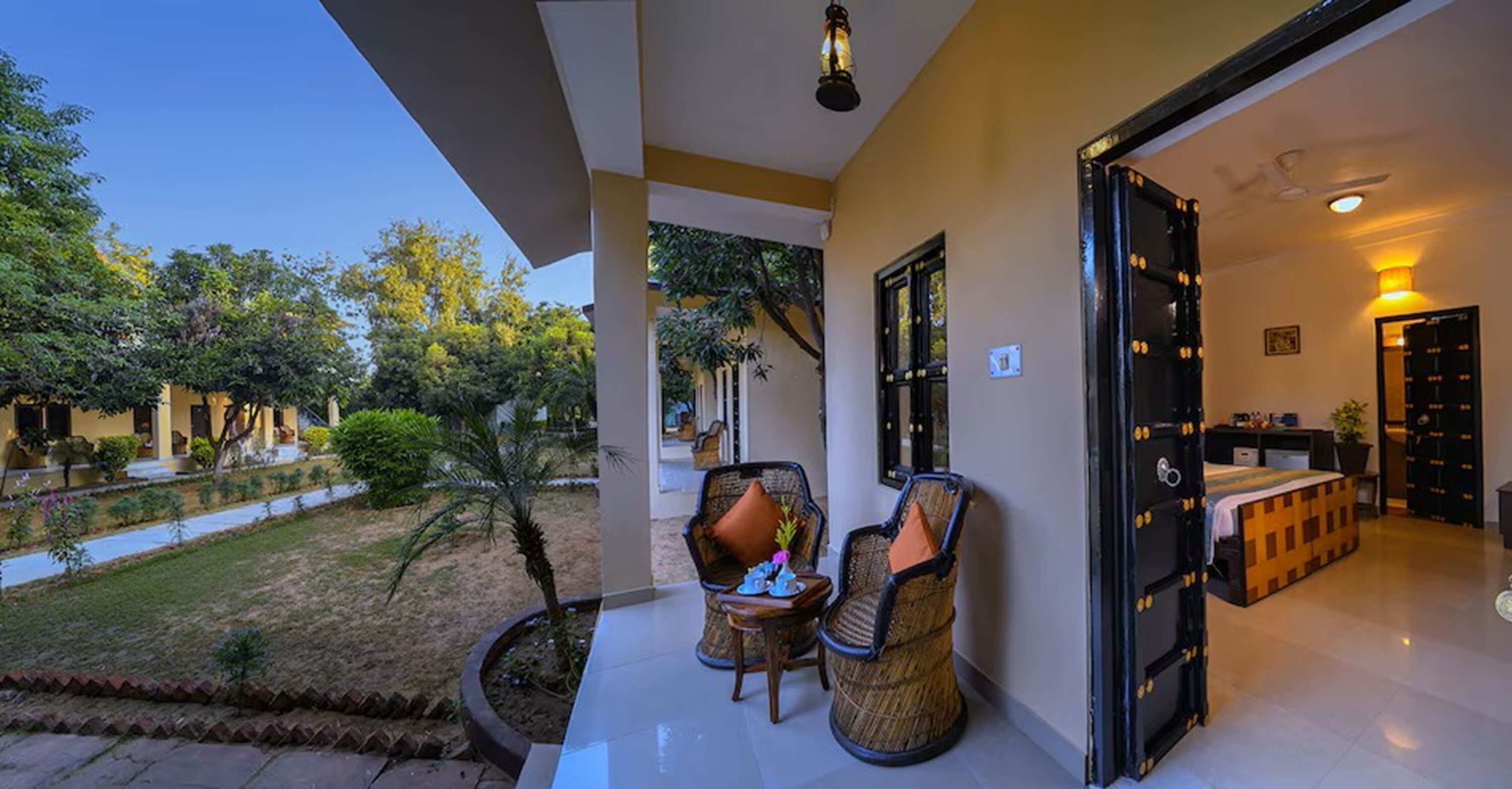 A hotel room with a balcony, a bed, a small table, and chairs.