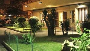 A hotel with a well-maintained garden, a fenced parking area, and a building entrance with a sign. - A short walk from the Vatican Museums (3 minutes) and St. Peter Church.  (Roma)