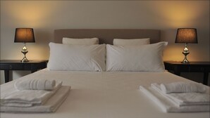 A neatly made bed with white linens and pillows, two bedside tables with lamps, and folded towels on the bed. - A short walk from the Vatican Museums (3 minutes) and St. Peter Church.  (Roma)