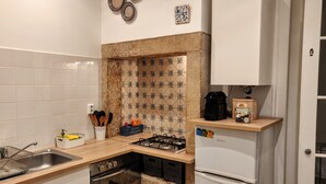 A kitchen with white cabinets, a gas stove, a built-in oven, and a refrigerator. - Sunny 2BR - Av. D. Carlos I, Lisbon (São Bento) (Lisboa)