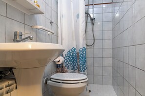 A bathroom with a white sink, toilet, and shower. - Villa Edera, apartment 20 meters from the sea (Castiglione della Pescaia)