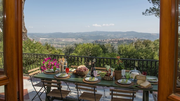 A table set for a meal with a scenic view of a valley and mountains in the background. - Villa Ombrosa 8, Emma Villas (Porano)