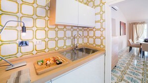 A modern kitchen with a geometric backsplash, a wooden countertop, and a dining area with a table and chairs. - Elegant penthouse apartment with amazing terrace! (Roma)