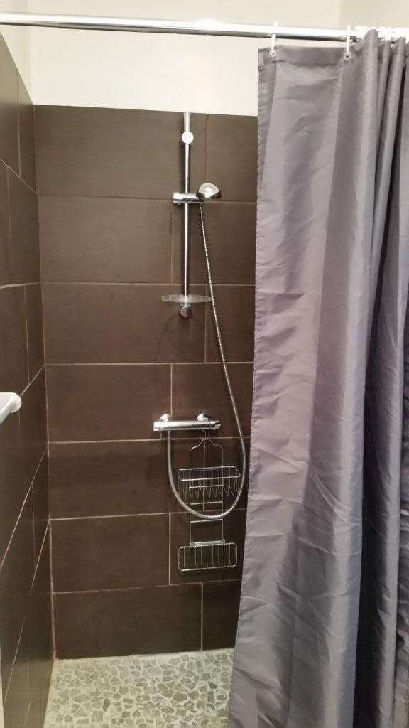 Een douchegedeelte met een douchekop, handdouche en een inbouwregendouche.