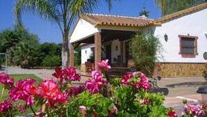 A white building with a tiled roof and a covered patio area.