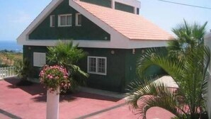 A two-story house with a sloped roof, a balcony, and a view of the ocean. - Chalet with pool in Candelaria (Candelaria)