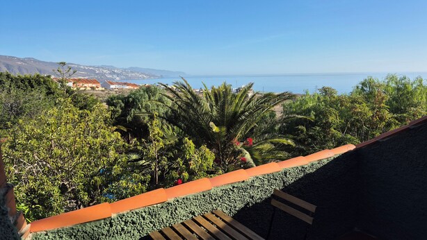 A balcony with a view of a coastal landscape, including a body of water and distant buildings. - Chalet with pool in Candelaria (Candelaria)