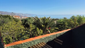 A balcony with a view of a coastal landscape, including a body of water and distant buildings. - Chalet with pool in Candelaria (Candelaria)