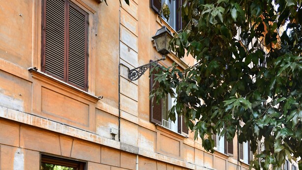 Une rue pavée bordée d’un bâtiment doté d’une porte et de fenêtres en bois.