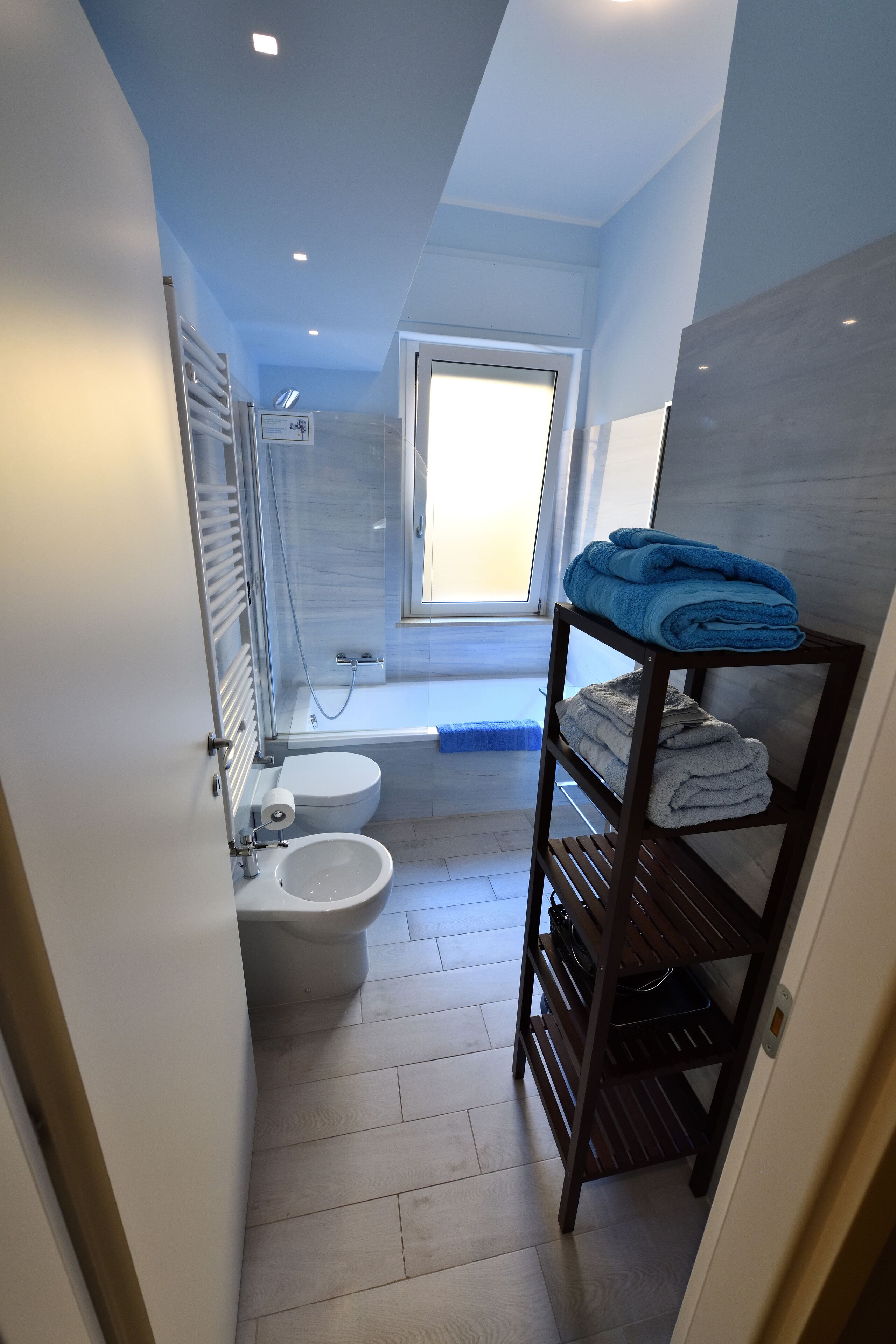 Un baño compacto con inodoro, bidé y zona de ducha.