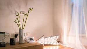 A room with a wooden shelf holding a vase with green plants, a vintage telephone, and a mirror light. - Garibaldi Roof Garden - Terrace with spectacular views of S. Peter and Gianicolo (Roma)