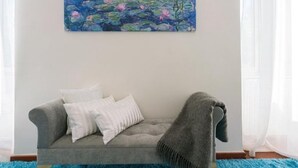 A living room with a grey sofa, white pillows, and a blue rug. - Garibaldi Roof Garden - Terrace with spectacular views of S. Peter and Gianicolo (Roma)