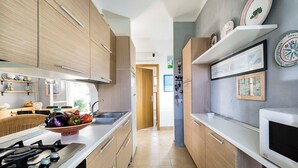 Eine moderne Küche mit Holzausstattung, einer Edelstahl-Spüle und einem Gasherd.