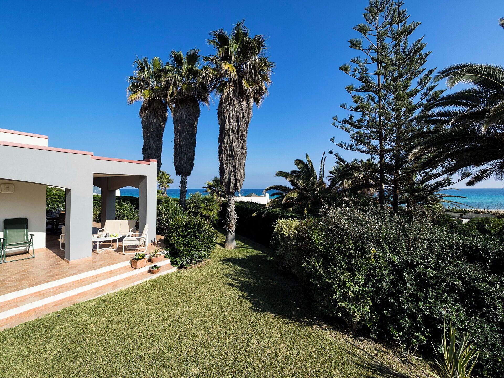 A modern house with a patio area, a pool, and a view of the ocean.