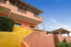 A multi-story building with a flat roof, a balcony, and a staircase leading to the upper level. - Beautiful apartment sea view - Residence Eolo (Santa Teresa Gallura)