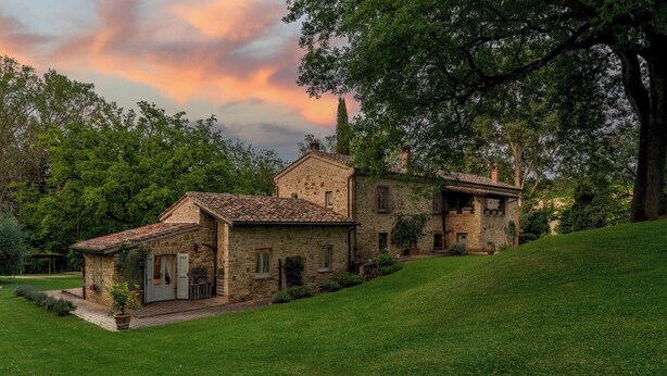 A stone house with a tiled roof, surrounded by lush greenery and trees. - Il Molinaccio 14+2, Emma Villas (Montepulciano (Siena))