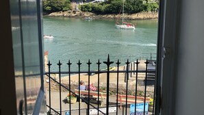 Vue d’un port avec des bateaux, un mur de pierre et un panneau indiquant la rue Station Road Passat.
