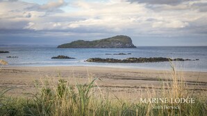 A coastal view with a small island and a beach.