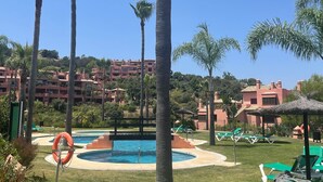 A pool area with palm trees, lounge chairs, and a lifebuoy. - Golf, Tennis, Paddle Tennis, Gym, 4 pools including heated, (Ojen)