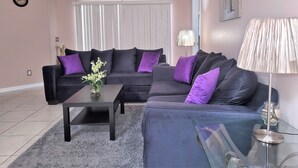 A living room with a black sofa set, a coffee table, and a glass table with a lamp. - Luxury Executive Villa with Private Pool, Spa & Games Room 10 miles from Disney (Davenport)