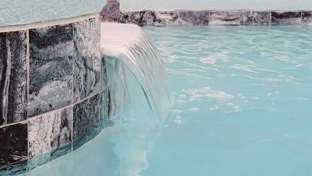 A pool with a waterfall feature. - Luxury Executive Villa with Private Pool, Spa & Games Room 10 miles from Disney (Davenport)