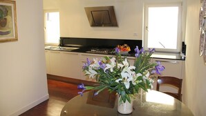 Una cocina compacta con estufa, ventana y zona de comedor con mesa y sillas.