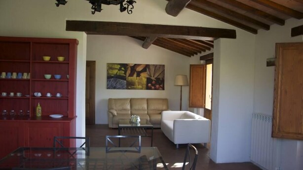 A dining area with a glass table and chairs, a red cabinet with dishes, a beige sofa, and a painting on the wall. - House / Villa - Cetona (Cetona)