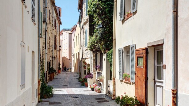 A narrow cobblestone street flanked by buildings with shutters and potted plants. - Beautifully renovated townhouse for 4 guests in Antibes with outdoor space. (Antibes)