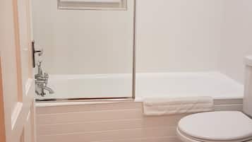 Een bad/douchecombinatie, een haardroger, toiletpapier