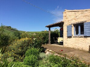 A stone house with a wooden pergola and a window with shutters. - Charming Countryhouse with huge garden - stunning view - with Heating! (Petritoli)