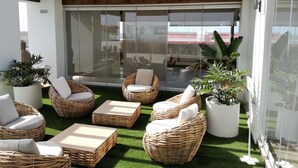 A covered outdoor seating area with wicker furniture and potted plants. - PRETTY APARTMENT WITH POOL AT BRISTOL SUNSET  (Corralejo)