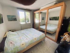 A bedroom with two beds, a wardrobe, a mirror, and a window. - La Salvetat Saint Gilles: House / Villa - LA SALVETAT ST GILLES (La Salvetat-Saint-Gilles)